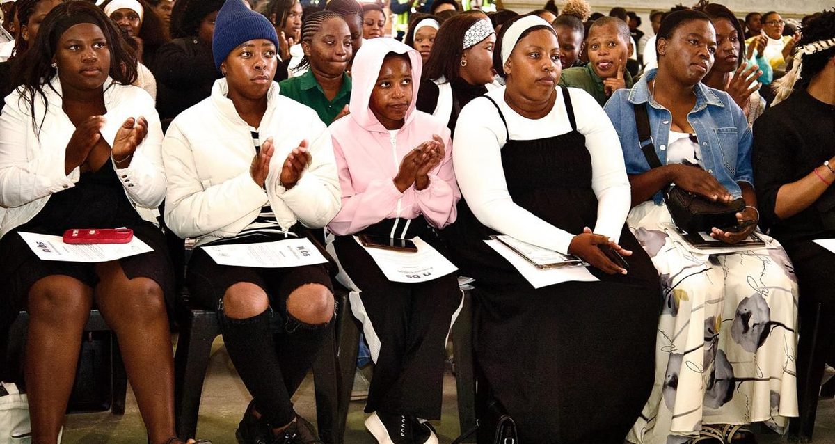 A seated audience of learners applauding at a NIBS event.