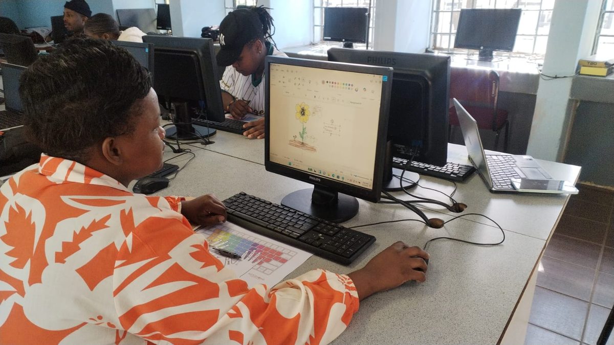 A learner working at a desktop computer in the Katlehong Computer School lab.