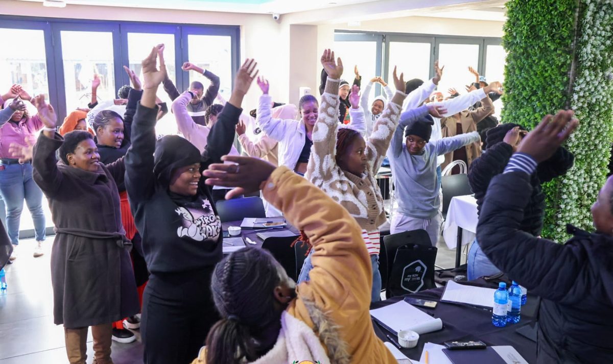 Learners with their hands raised during an energetic NIBS session.
